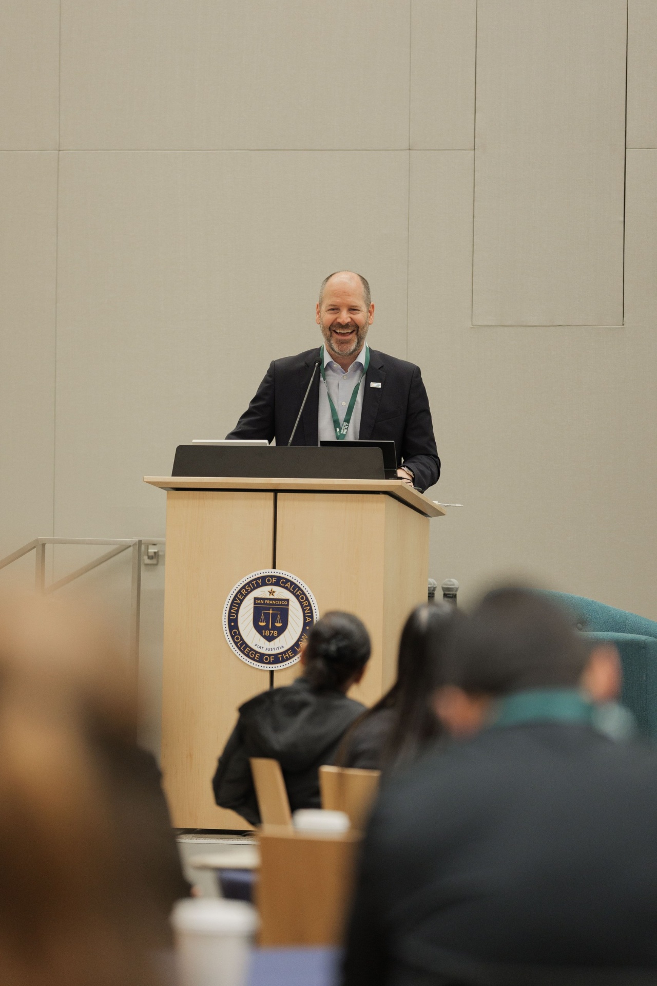 Nelson Switzer smiling from the UC Law podium during his Capital Day keynote