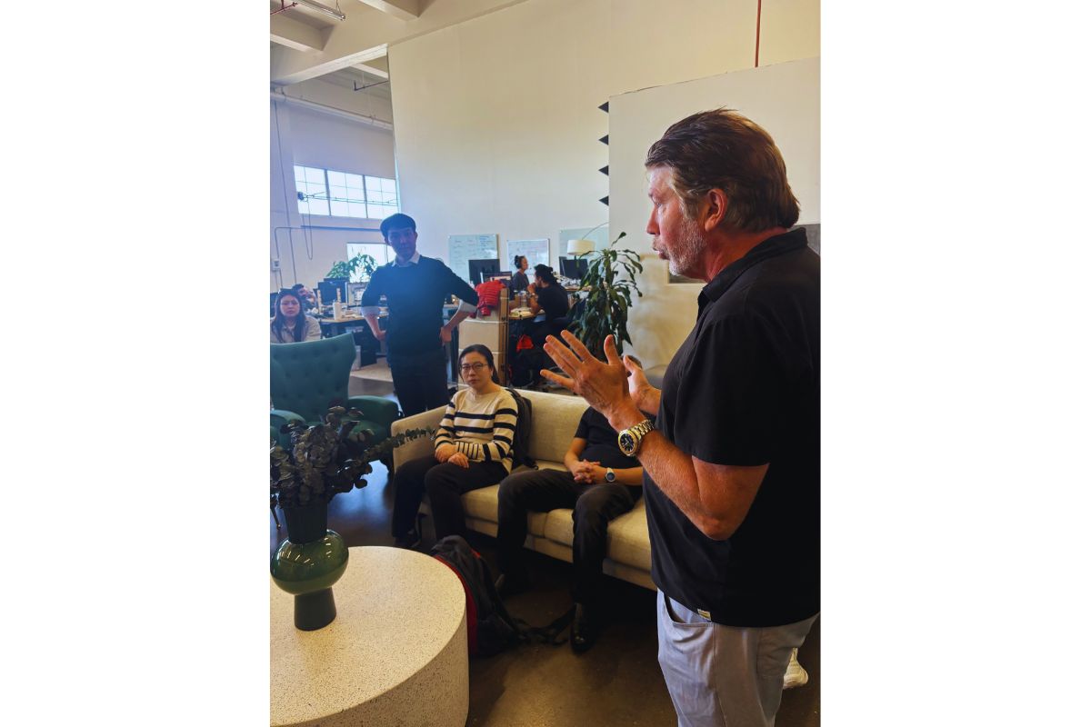 SOSV host speaking with hands raised to a small group of seated delegates on a sofa during the Frontiers Day visit in San Francisco