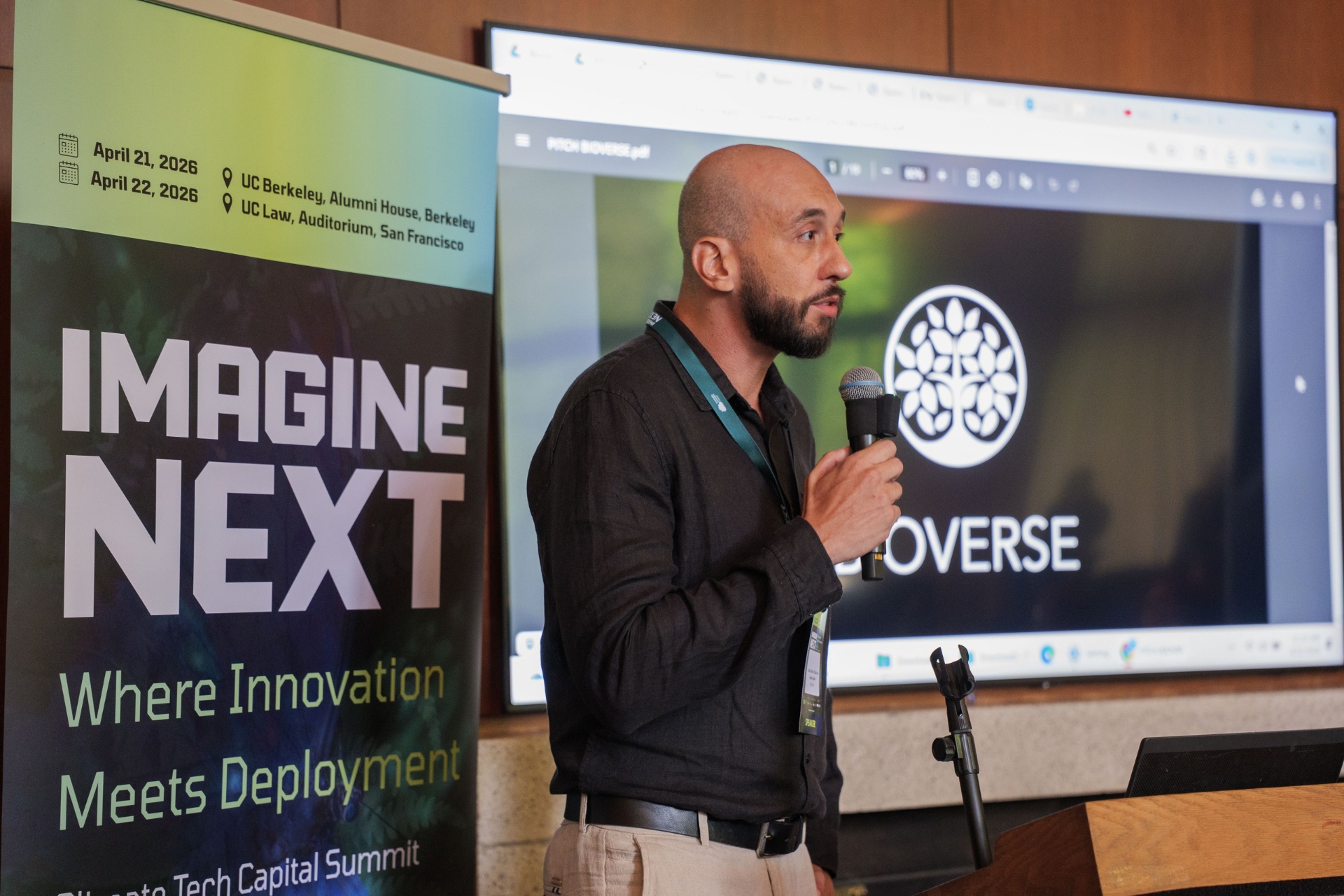 Bioverse pitch deck on screen beside the Imagine Next banner