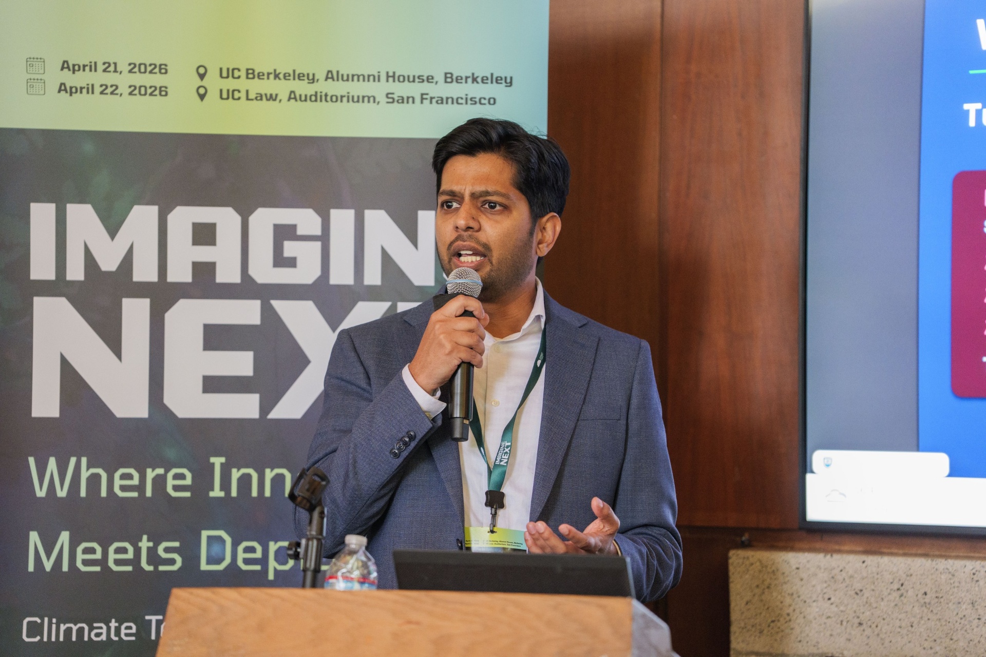 Ashray Manur pitching ChargeCatalyst beside the Imagine Next banner