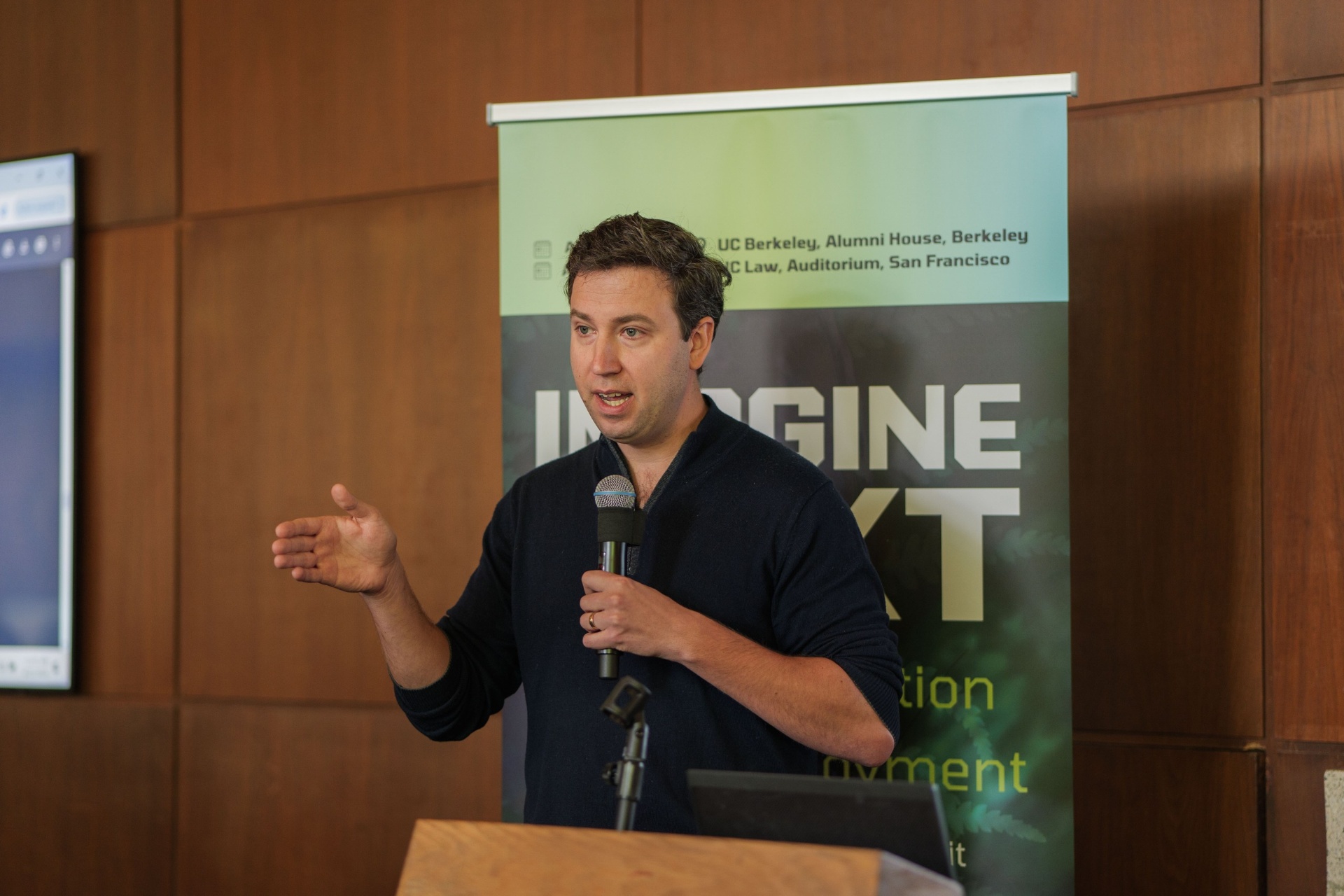 Master the Model speaker mid-presentation by the Imagine Next backdrop