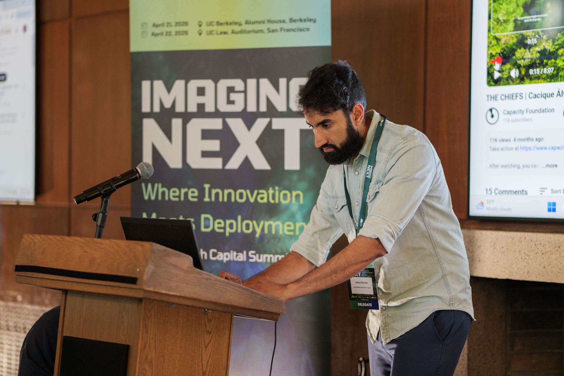 Speaker at the podium with Imagine Next banner