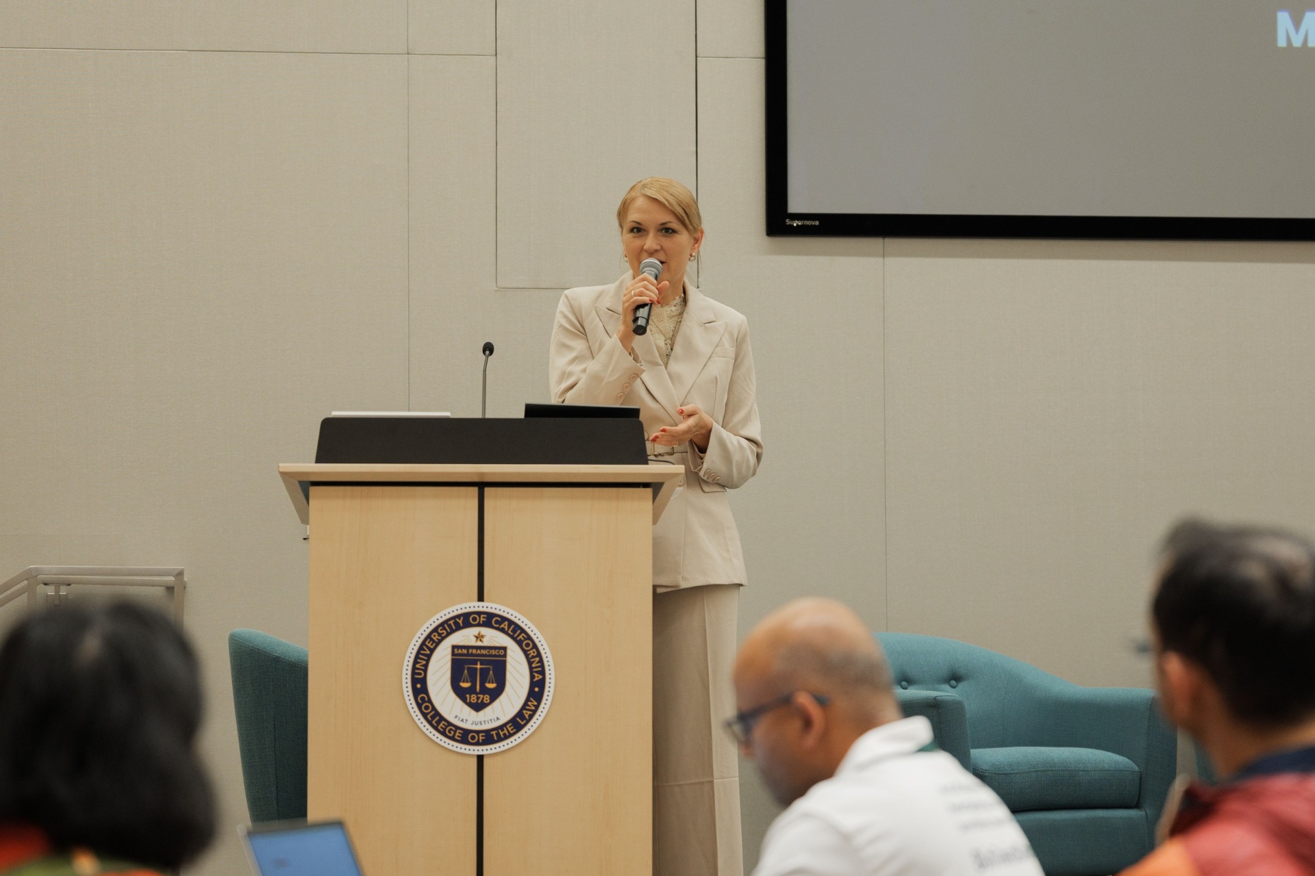 Capital Day speaker at the UC Law SF podium with the University of California College of the Law seal speaking into the microphone