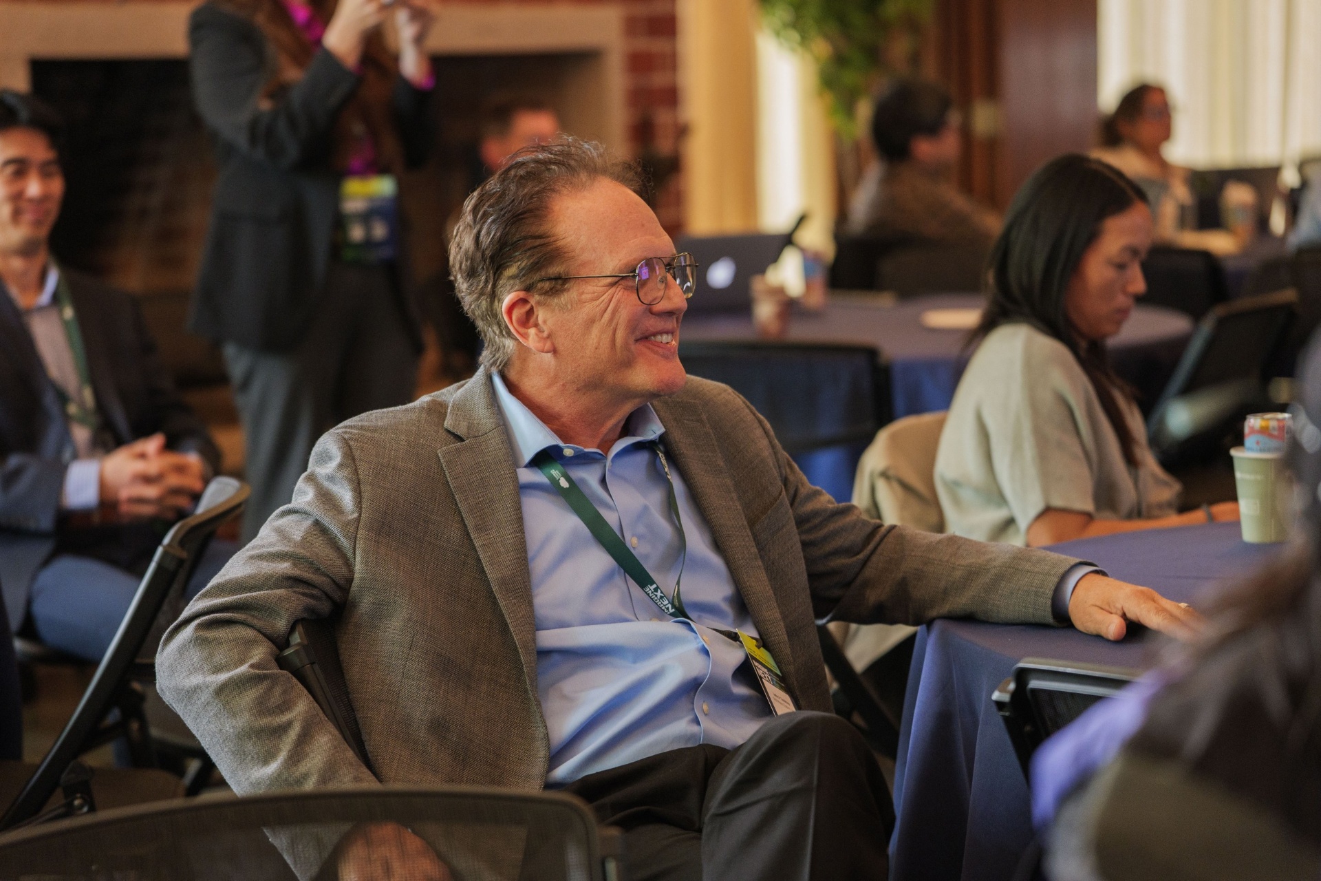 Delegate smiling during a pitch session in the audience