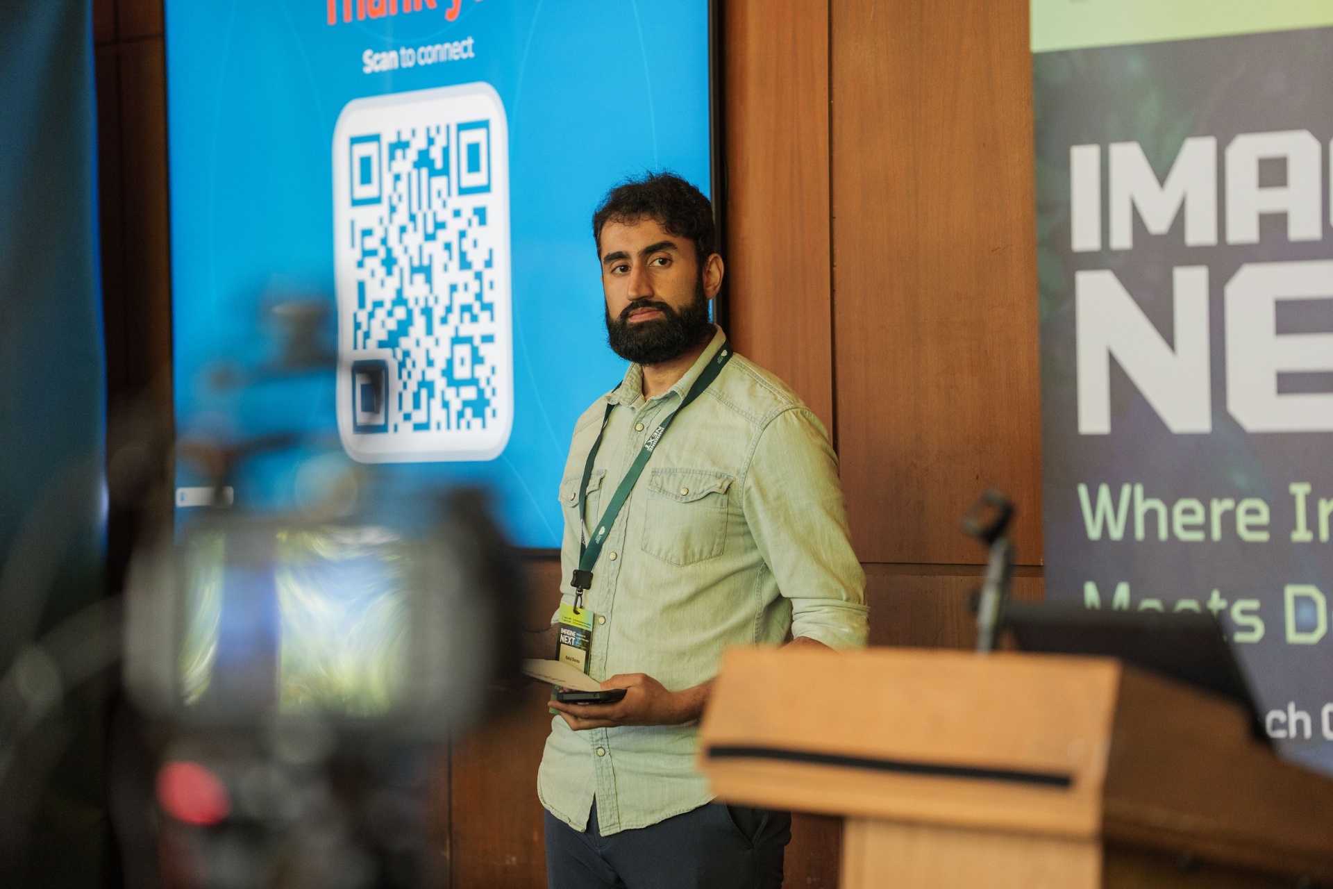 Rahul Sharma beside the Thank You QR code screen at the podium